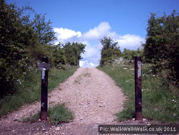 Stone-surfaced uphill cycle path between posts